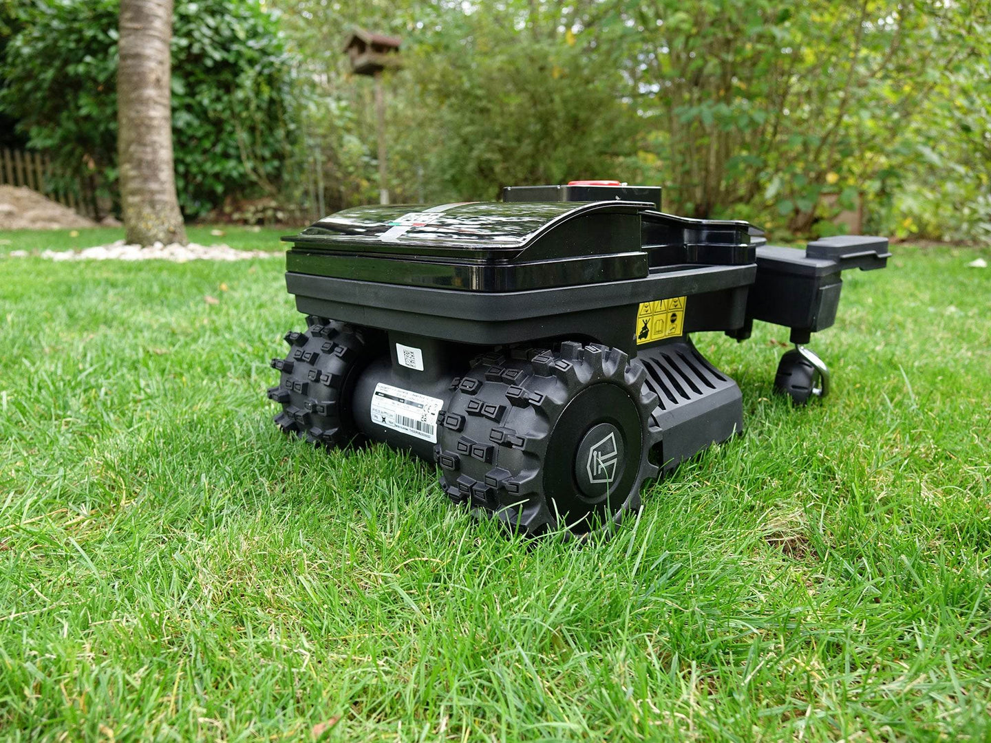 Das Bild zeigt den Mähroboter von hinten, wobei das Typenschild deutlich sichtbar ist.