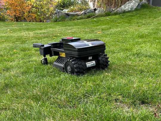 Das Bild zeigt den Mähroboter von hinten, wobei seine großen und breiten Räder gut sichtbar sind.