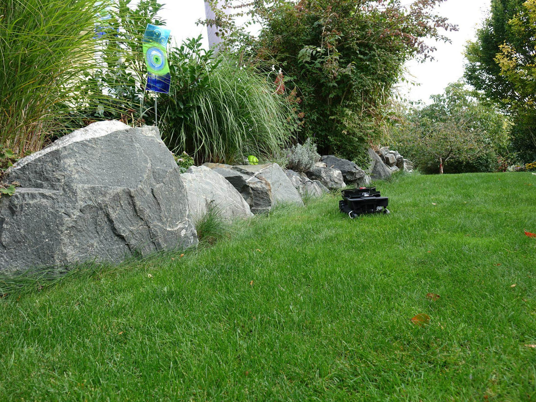 Das Bild zeigt den schwarzen Mähroboter Techline ZR aus der Vogelperspektive, wie er einen Abhang hinunterfährt.